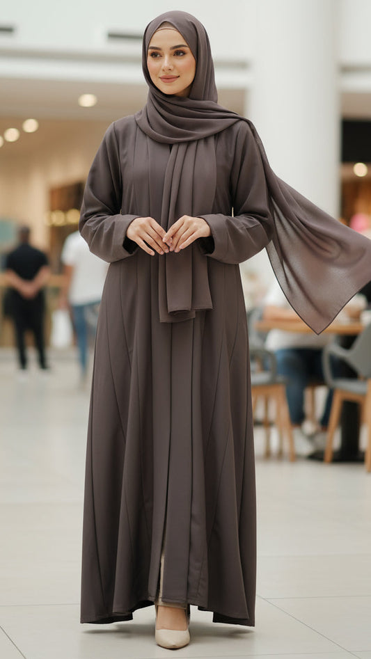 Woman in a brown abaya standing in a shopping mall.